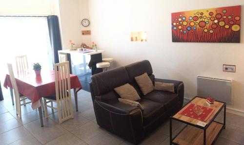 ein Wohnzimmer mit Sofa und Tisch in der Unterkunft appartement T2 CHALOSSE in Bahus-Soubiran
