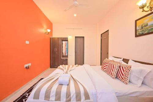 a large white bed in a room with orange walls at Lifeline Villas- Backwater Breeze Valley View Luxurious Infinity Pool Villa With Huge Open Area in Mahabaleshwar