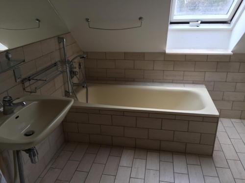 a bathroom with a bath tub and a sink at Bagsværd Apartment in Hareskovby