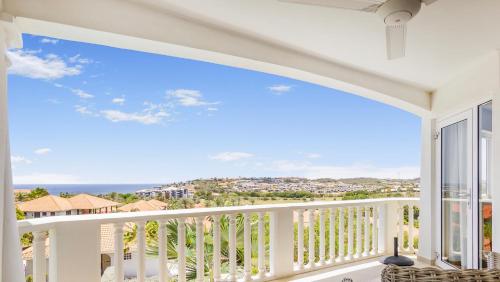 a balcony with a view of the ocean at Modern appartement bij zee met zwembad op Blue Bay - Tripletree the hill in Sint Michiel