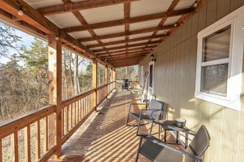 a wooden porch with chairs and a table on it at Hillside Hideaway cabin in Butler