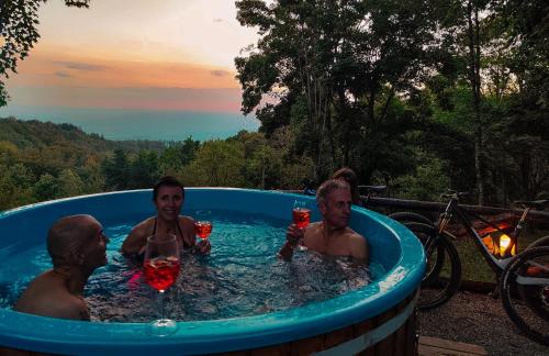 three men in a hot tub with drinks at casa al taverni in Falciano