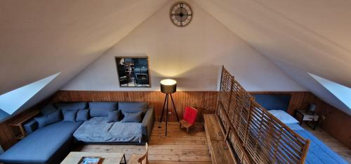 a living room with a blue couch in a attic at Loft des Cimes - Evasion en montagne avec local vélo privé in Cornimont