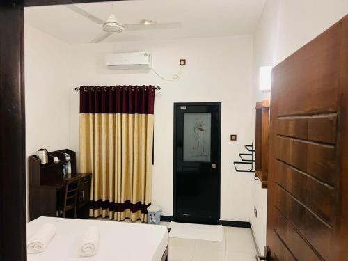 a room with a black door and a curtain at Wild Blossom Sigiriya in Sigiriya