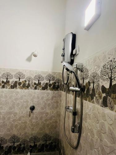 a shower stall in a bathroom with a shower at Wild Blossom Sigiriya in Sigiriya