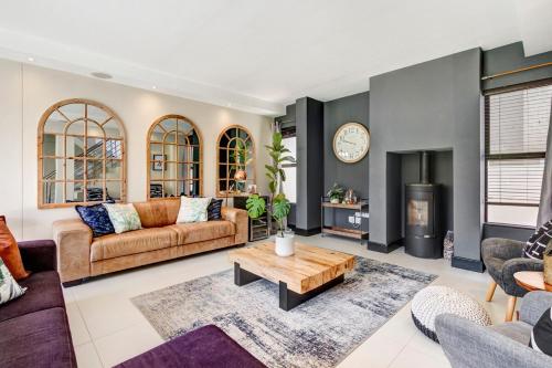 a living room with a couch and a table at 3 Bedroom Villa in Big Bay in Cape Town