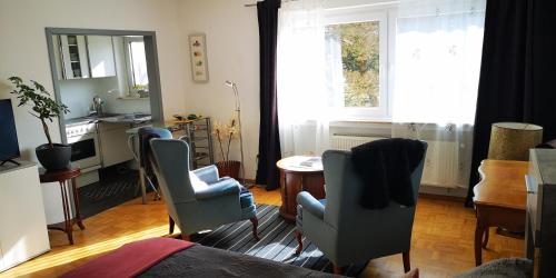 Una sala de estar con sillas y una mesa y una ventana. en Pinienblick, en Erkrath