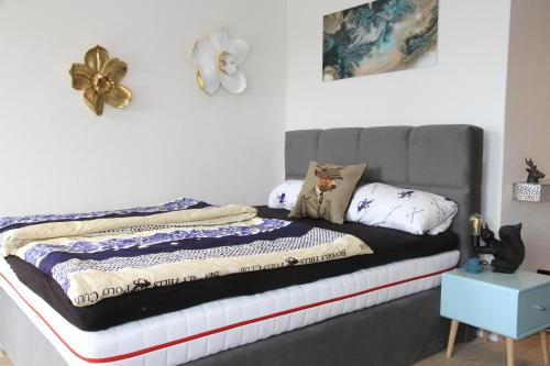 1 cama con cabecero gris en un dormitorio en Apartment Tälerblick Maxi, neu modernisiert, en Böbrach