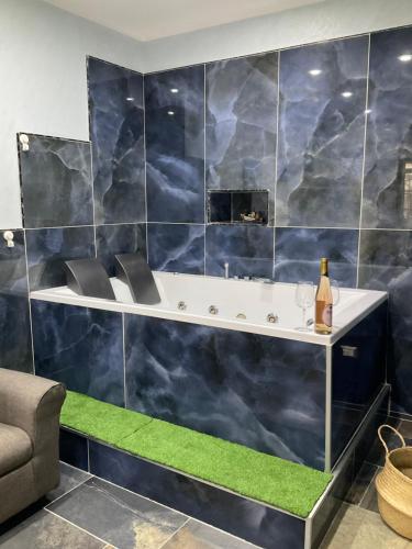 a bathroom with a blue tiled wall with a bath tub at Eruption1669 in Catania
