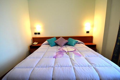 a large bed in a bedroom with two lights on at Hotel La Cantina in Alfonsine
