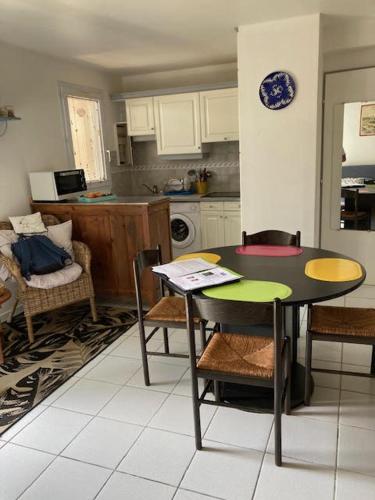 une cuisine avec une table et des chaises dans une cuisine dans l'établissement résidence les marines, à Saint-Vincent-sur-Jard