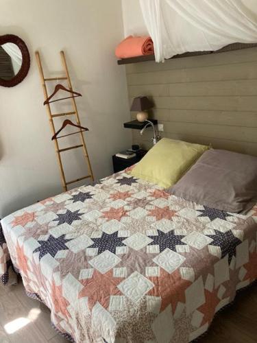 un lit avec une couette dessus dans une chambre dans l'établissement résidence les marines, à Saint-Vincent-sur-Jard