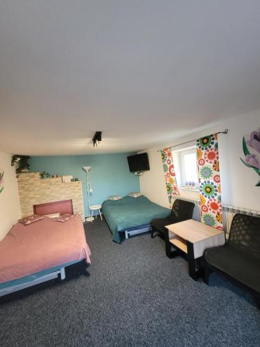 a hotel room with two beds and a couch at Apartamencik Pod Krokusem 2 in Rabka