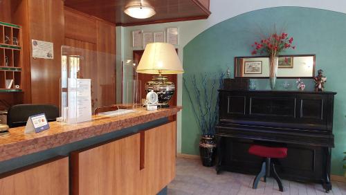 a bar with a lamp and a piano in a room at Hotel Etrusco in Sesto Fiorentino