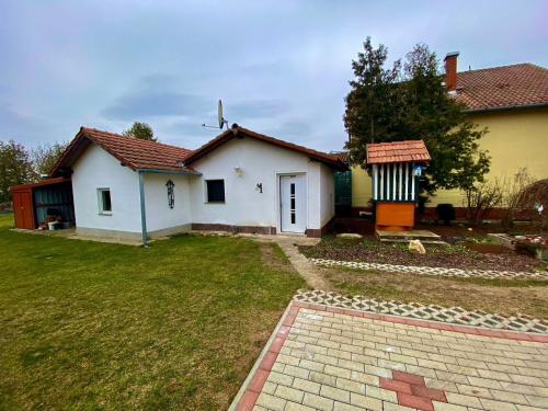 a small white house with a grass yard at Jägerlodge in Lócs