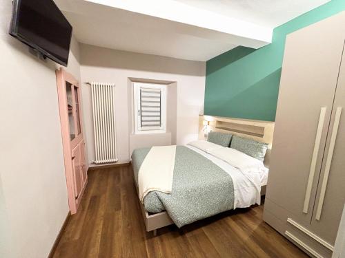 a small bedroom with a bed and a flat screen tv at Torre Antica Montese Guest Room in Montese