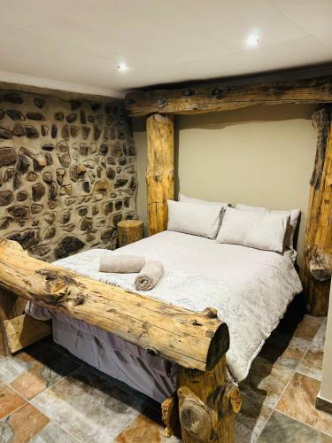 a bedroom with a wooden bed in a stone wall at The Wool House & Pablo's carolina in Carolina