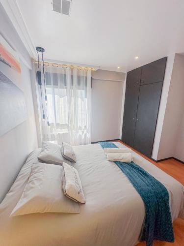 a large white bed in a room with a window at Beach Apartment in Armação de Pêra