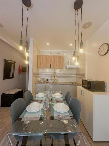 a dining room with a glass table and chairs at Beach Apartment in Armação de Pêra