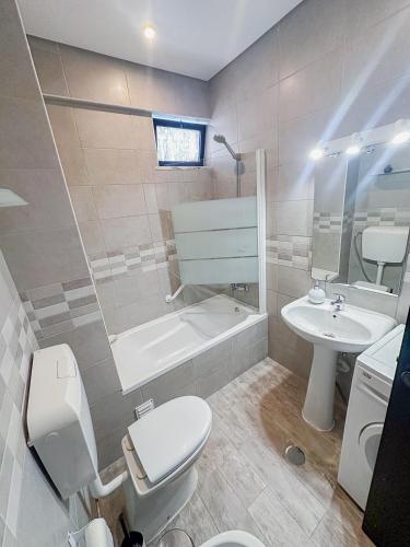 a bathroom with a toilet and a tub and a sink at Beach Apartment in Armação de Pêra