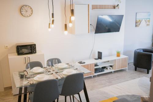 a dining room with a table and chairs and a tv at Beach Apartment in Armação de Pêra
