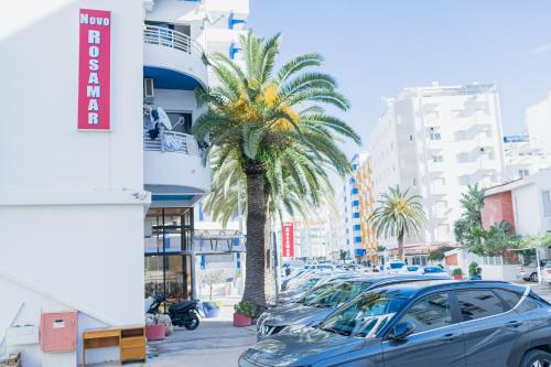 a street with cars parked in front of a building at Beach Apartment in Armação de Pêra