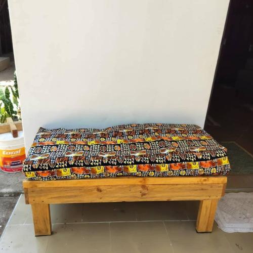 a bench with a colorful blanket on top of it at Botanic Hideaway Home, 5km from Mwanza airport in Mwanza
