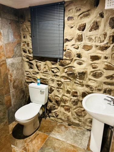 a stone bathroom with a toilet and a sink at The Wool House & Pablo's carolina in Carolina