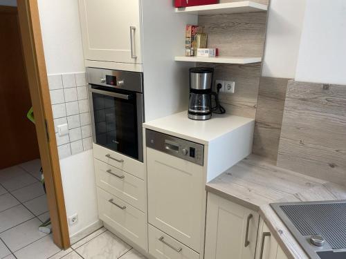 a kitchen with white cabinets and a blender on a counter at Sonnige Südwohnung mit Terrasse, Badesee in Forchtenberg