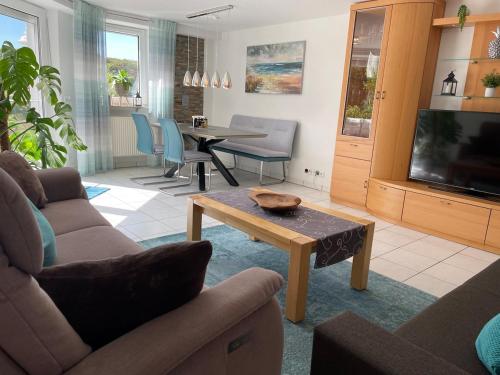 a living room with a couch and a table at Sonnige Südwohnung mit Terrasse, Badesee in Forchtenberg