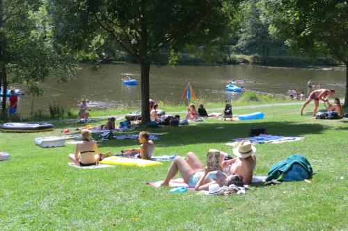 a group of people laying in the grass at a park at Sonnige Südwohnung mit Terrasse, Badesee in Forchtenberg