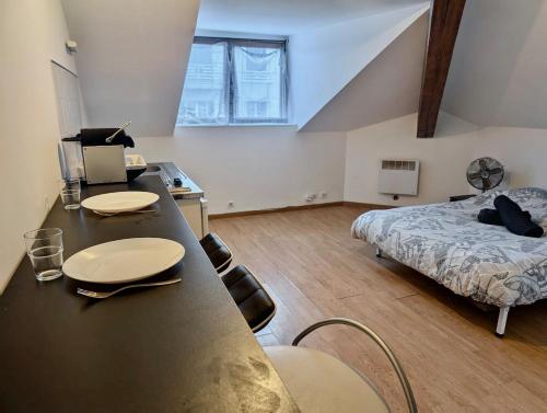 une chambre avec un lit et une table dans une pièce dans l'établissement Studio Hyper Centre au Calme, Confort & Équipé, à Grenoble