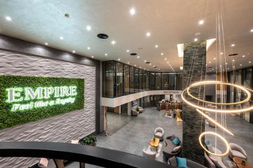 an office lobby with a green sign on the wall at Empire Balneo & Spa Hotel in Hisarya