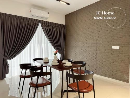 a dining room with a table and chairs and a brick wall at Kluang Gunung Lambak view Family Suites in Kluang
