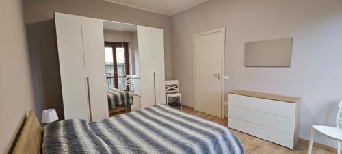 a bedroom with a bed and a dresser in it at Avilianum 48 in Vigliano Biellese