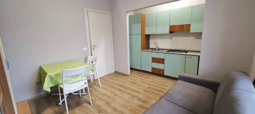 a living room with a table and a kitchen at Avilianum 48 in Vigliano Biellese