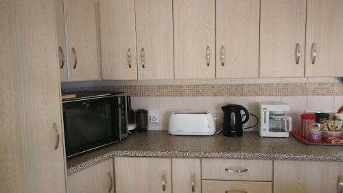 a kitchen counter with a microwave and a toaster oven at The Third Dolphin in Herolds Bay
