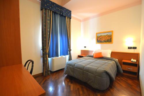 a bedroom with a bed and a blue curtain at Hotel La Cantina in Alfonsine