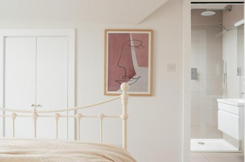 a bedroom with a bed and a picture on the wall at Contemporary 2 Bed Loft Honor Oak, London Apt in London