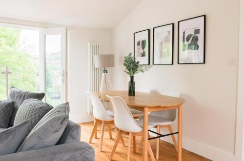 a dining room with a table and a couch at Contemporary 2 Bed Loft Honor Oak, London Apt in London