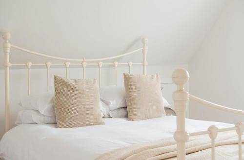a white bed with two pillows on top of it at Contemporary 2 Bed Loft Honor Oak, London Apt in London
