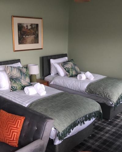 a room with two beds and a couch at The Rhu Inn in Rhu