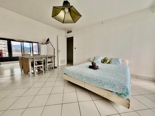 Un dormitorio con una cama y un comedor con una mesa. en Spacious 80m2 Apartment - 8th Floor, Free Parking, Sleeps 5, en Grenoble
