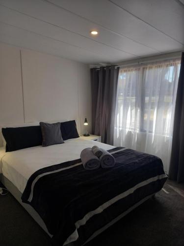 a bedroom with a large bed with two towels on it at Young Caravan and Tourist Park in Young