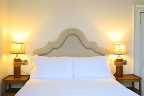 a bedroom with a white bed with two lamps at The Eagle House Hotel in Launceston