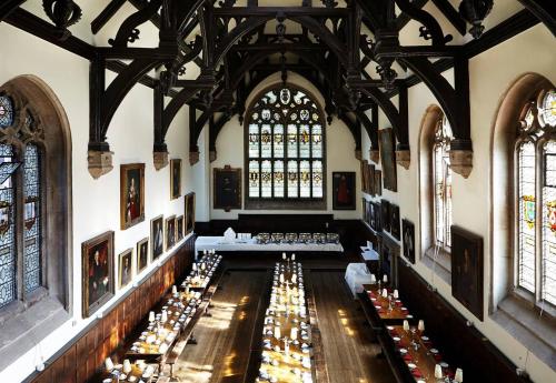 a room with many tables in a building with windows at Wadham College in Oxford