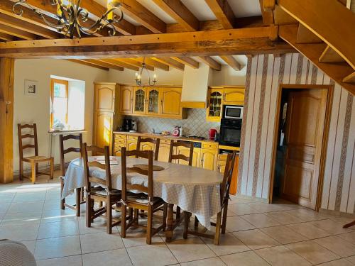 une cuisine avec une table et une cuisine avec des placards jaunes dans l'établissement Maison 10p à la campagne, à La Motte-Fouquet