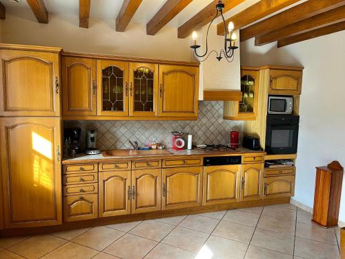 une grande cuisine avec des armoires et des appareils en bois dans l'établissement Maison 10p à la campagne, à La Motte-Fouquet