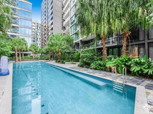 an outdoor swimming pool with palm trees and buildings at Luxury Stay With City View - Free Parking,Pool,Wifi in Brisbane