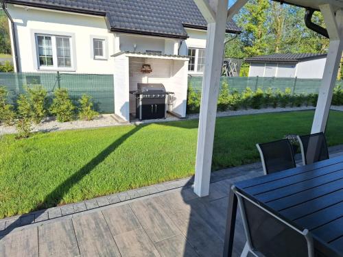 a backyard with a grill and a lawn at Karkonoskie Zacisze pod Śnieżką in Miłków